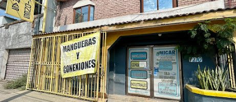 Fachada de HIGAR en Gral. Escobedo: portón amarillo con el rótulo «Mangueras y Conexiones» y la entrada del local.